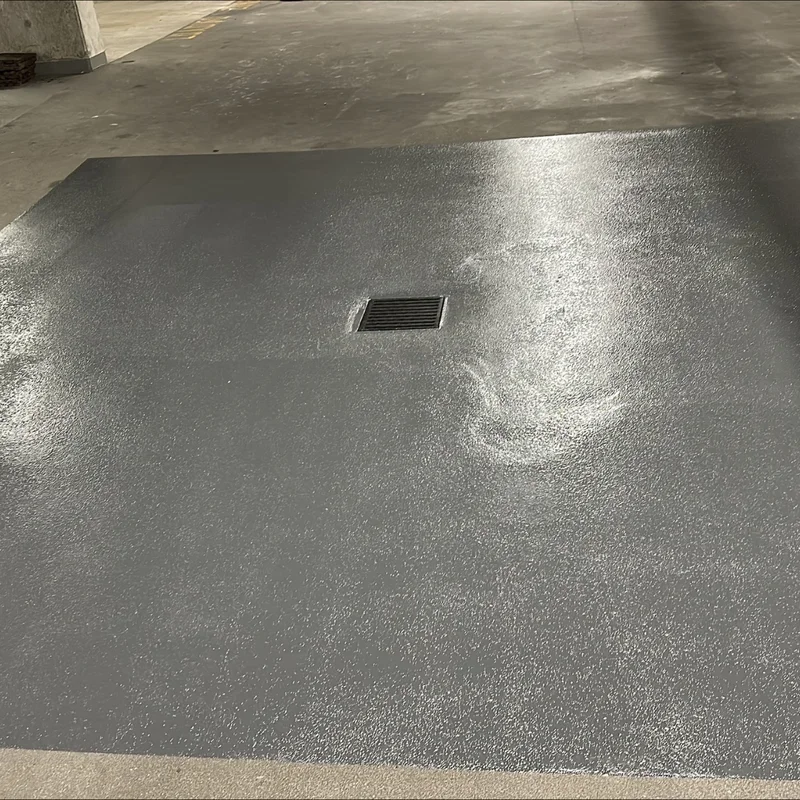 Parkade floor with a fresh protective traffic coating around a drain
